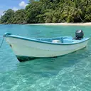 Illustrative photo: a small local boat on the turquoise Caribbean off a palm-lined beach